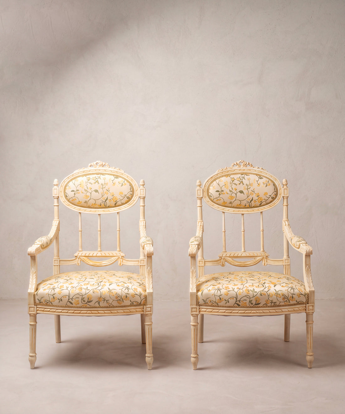 Pareja de sillones estilo Luis XVI pintados en crema con tapizado de flores vista frontal — Antique Arte y Decoración