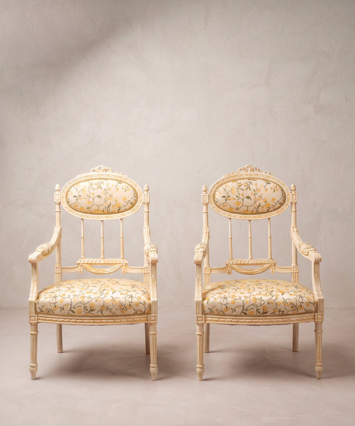 Pareja de sillones estilo Luis XVI pintados en crema con tapizado de flores vista frontal — Antique Arte y Decoración