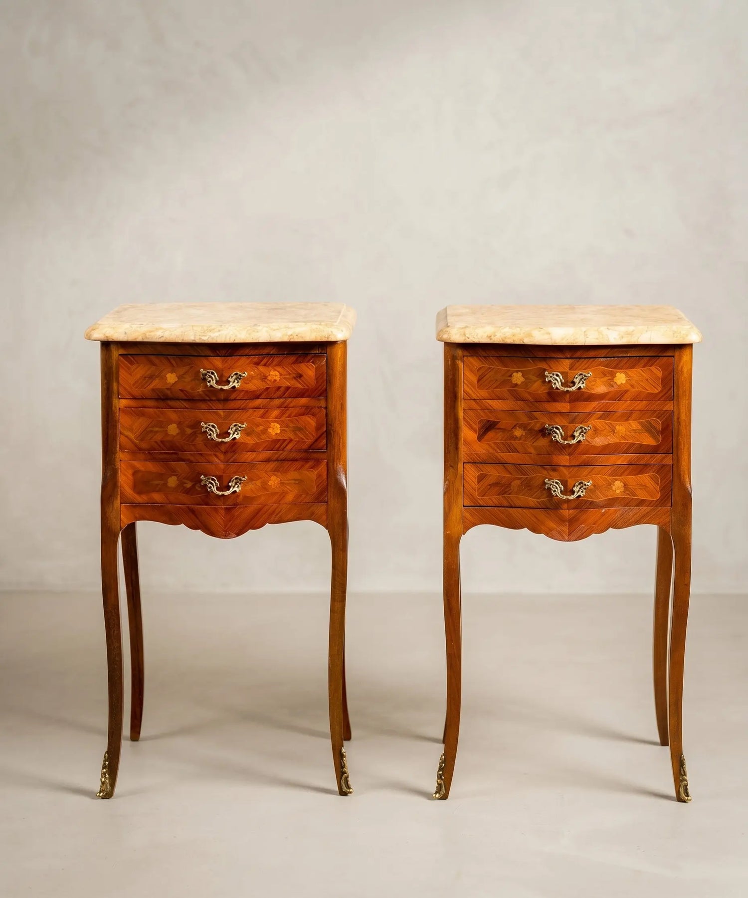 Pareja de mesitas de noche vintage con forma bombé en madera de marquetería y bronces dorados.