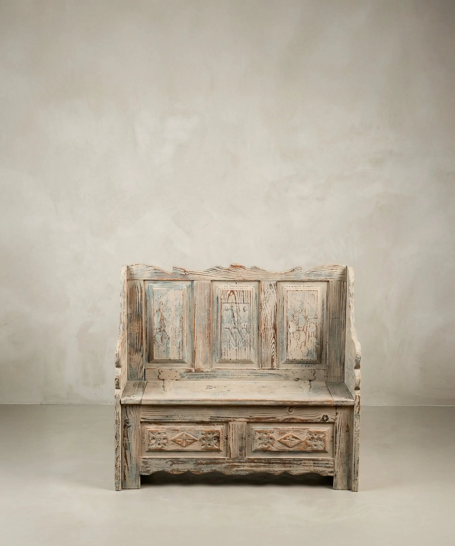 Banco arcón rústico pequeño de madera con respaldo panelado y pintura decapé.