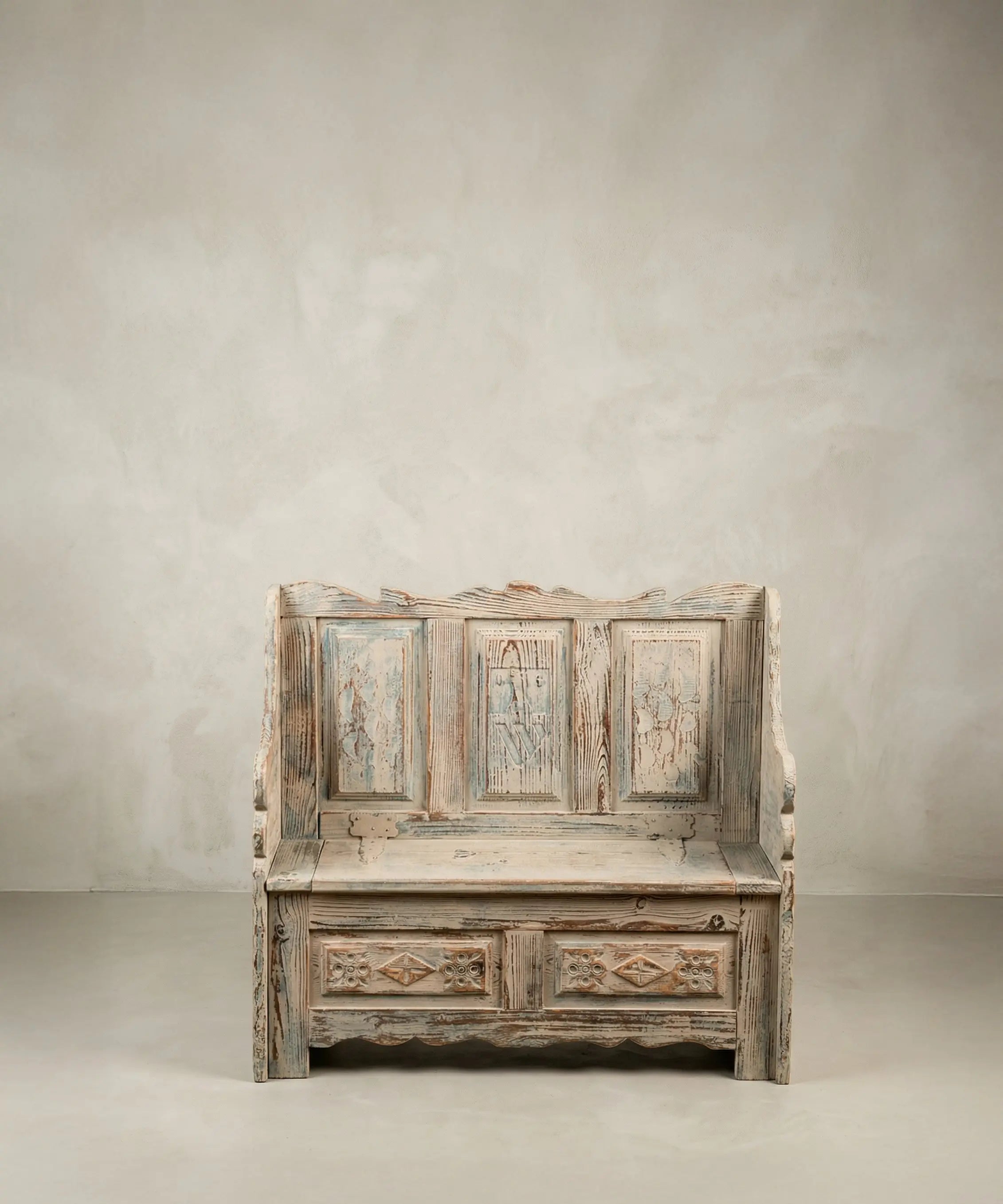 Banco arcón rústico pequeño de madera con respaldo panelado y pintura decapé.