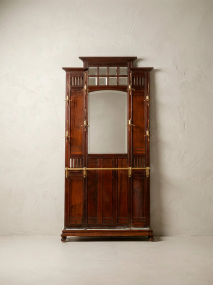 Mueble recibidor antiguo de madera de caoba con espejo central y colgadores de bronce.