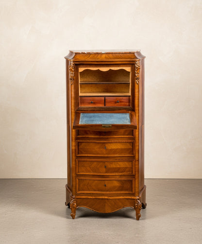 Secretaire-Semainier estilo Luis XV abierto mostrando el escritorio de terciopelo azul y cajones interiores en un salón elegante.