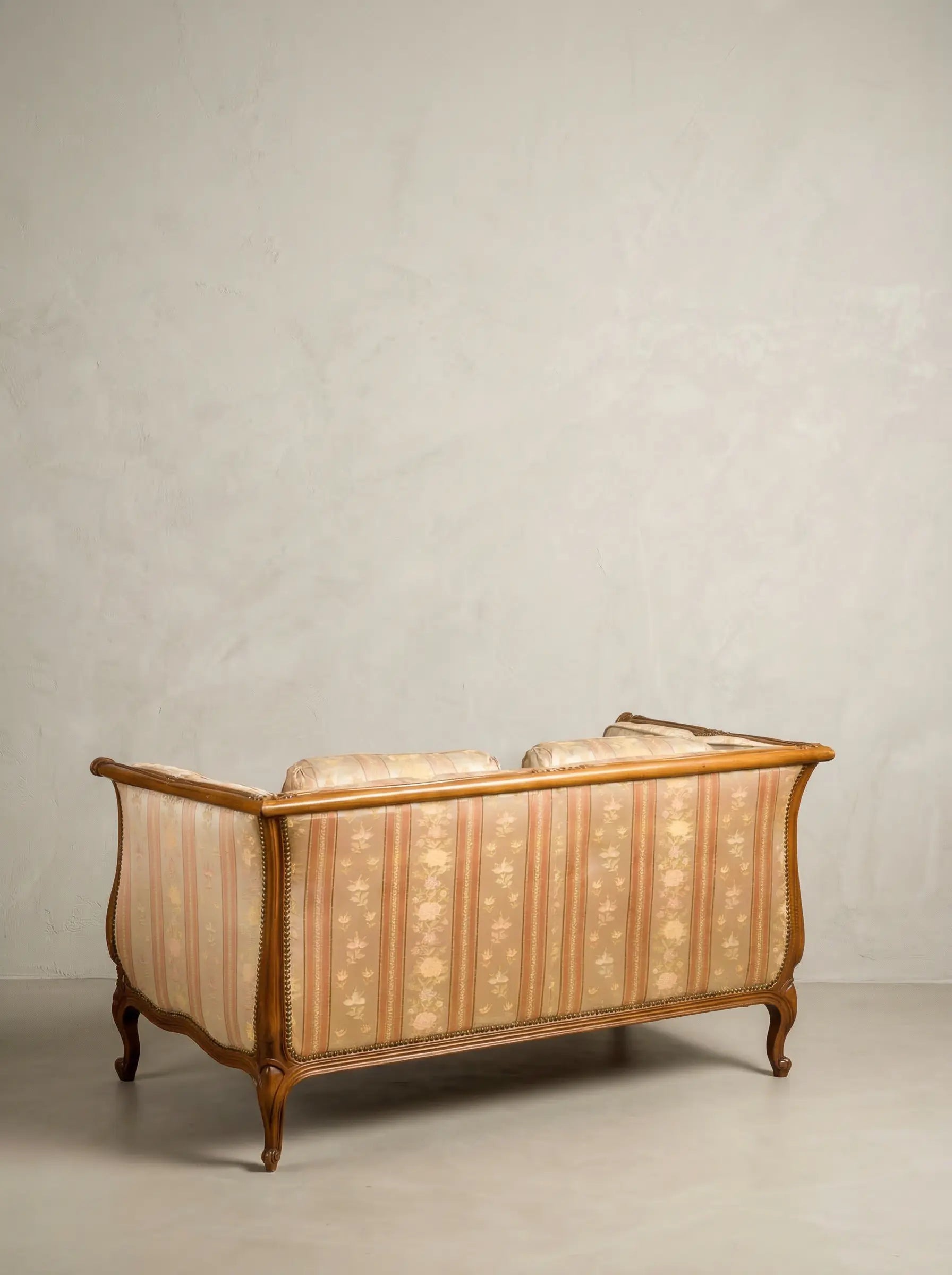 Parte posterior del respaldo tapizado de sofá estilo francés con estructura de madera vista.