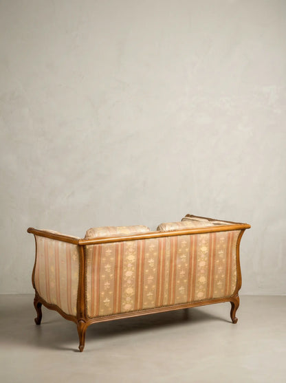 Parte posterior del respaldo tapizado de sofá estilo francés con estructura de madera vista.