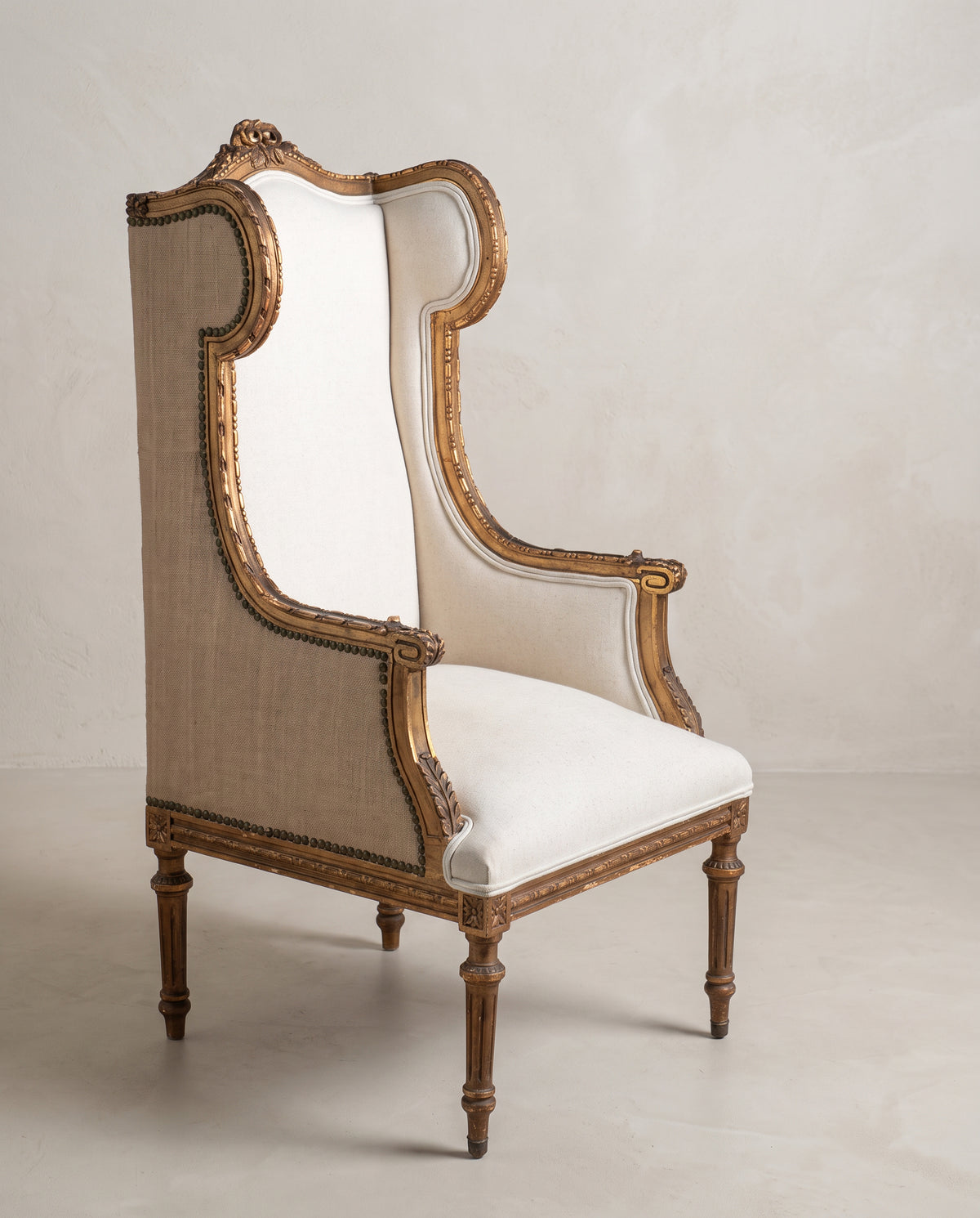 Sillón orejero Luis XVI vista lateral, costado de arpillera con tachuelas y talla dorada — Antique Arte y Decoración