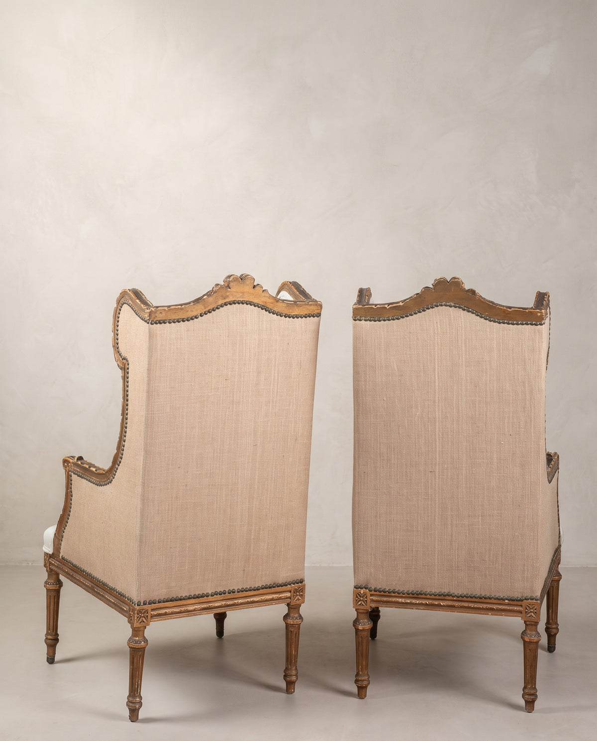 Pareja de sillones orejeros vista trasera, copete tallado y patas torneadas acanaladas — Antique Arte y Decoración