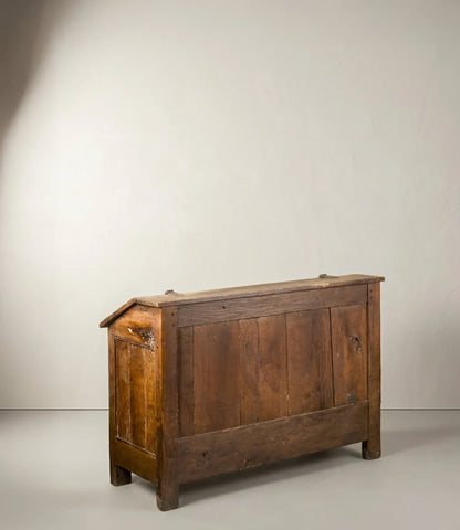 Vista trasera  ángulo de arca  antigua de madera con tapa inclinada y tallas de rombos.