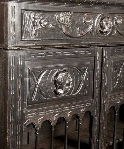 Detalle del panel superior con medallón figurativo de cabeza tallada y motivos circulares — Antique Arte y Decoración