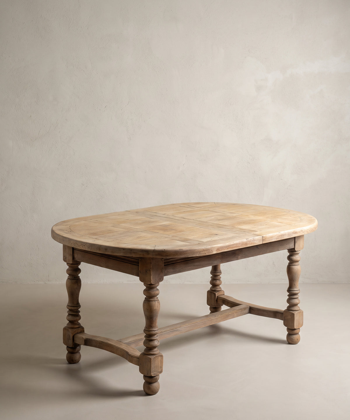 Mesa de comedor ovalada de roble lavado cerrada, vista diagonal con chambrana en H — Antique Arte y Decoración