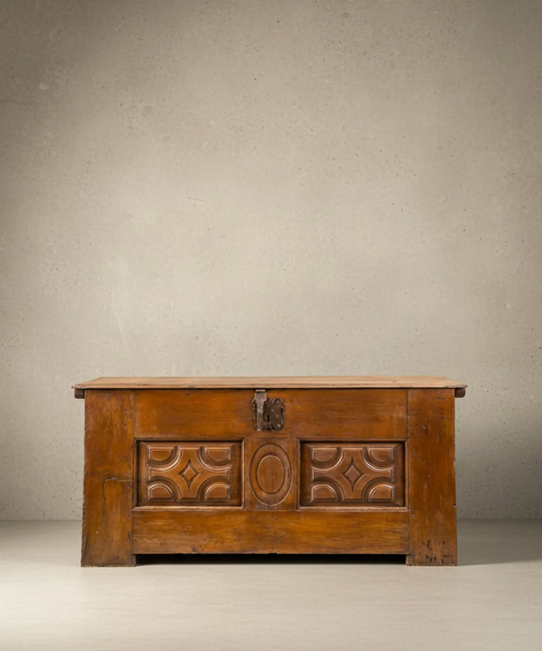 Arcón antiguo español de madera tallada con medallón central y herrajes de forja