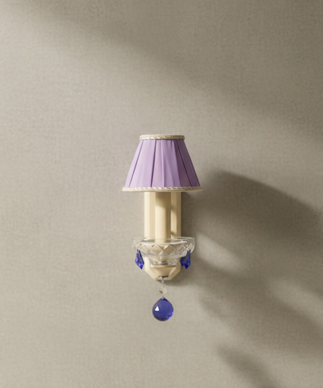 Vista frontal del aplique  mostrando la pantalla plisada malva y la esfera de cristal azul central sobre fondo neutro.