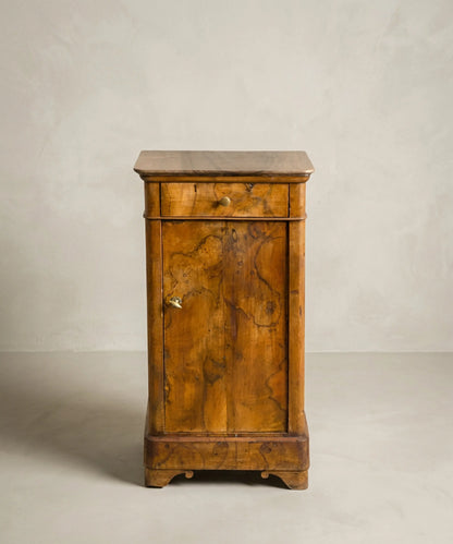 Mesita de noche antigua estilo Luis Felipe en chapa de raíz de nogal con cajón y puerta.