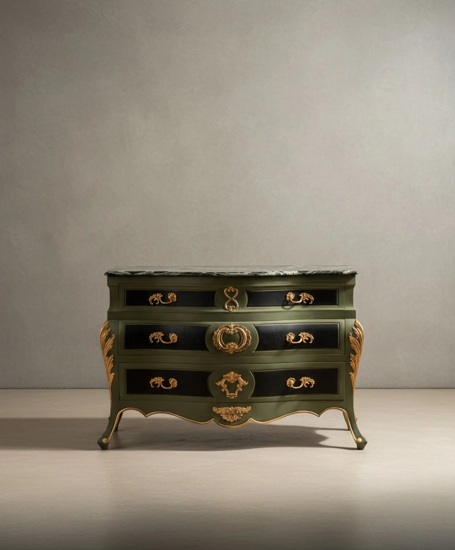 Vista frontal de cómoda bombe estilo Luis XV en verde oliva y negro con tapa de mármol y fondo neutro.