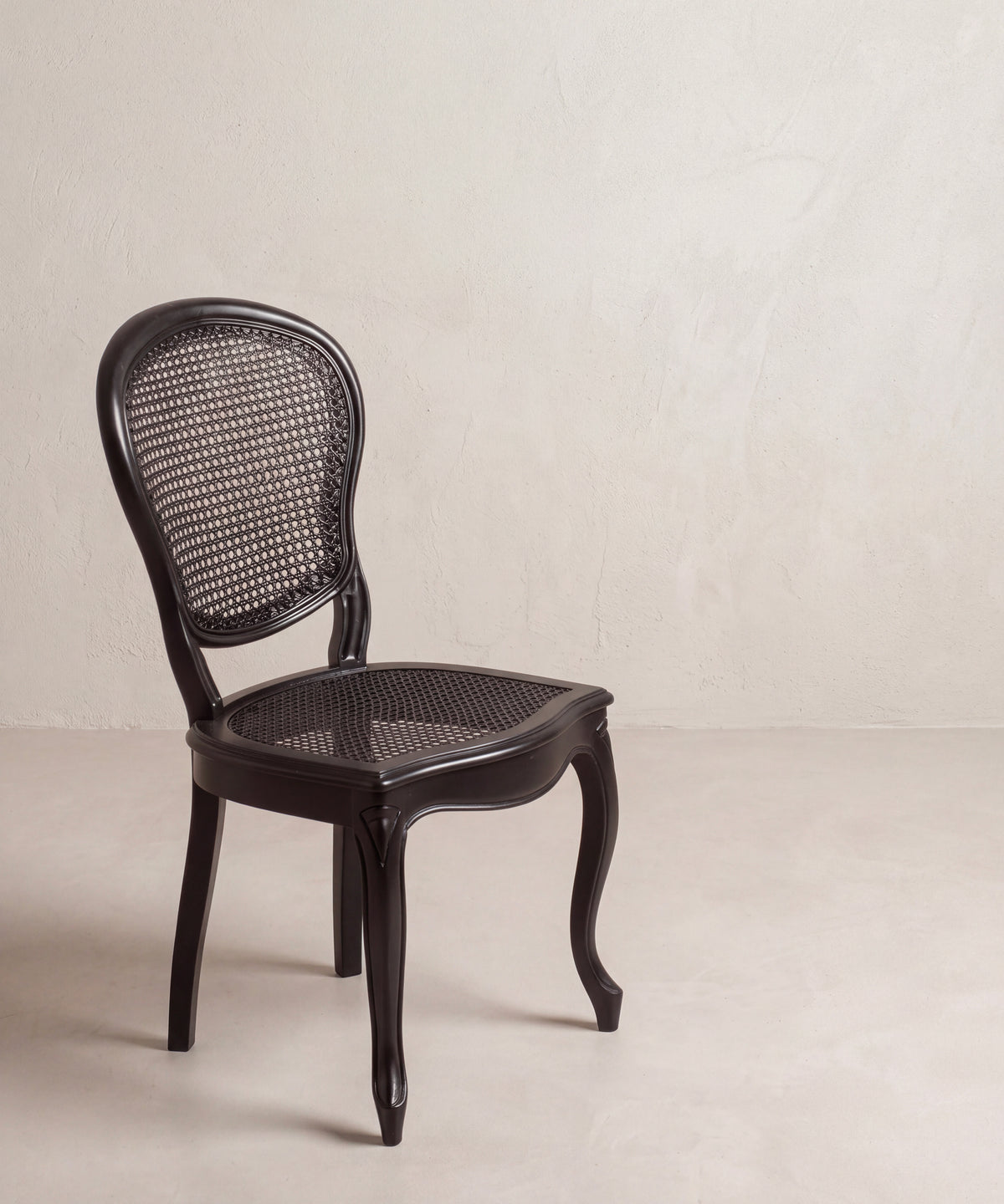 Silla de rejilla negra vista lateral con hoja tallada en la rodilla de la pata — Antique Arte y Decoración