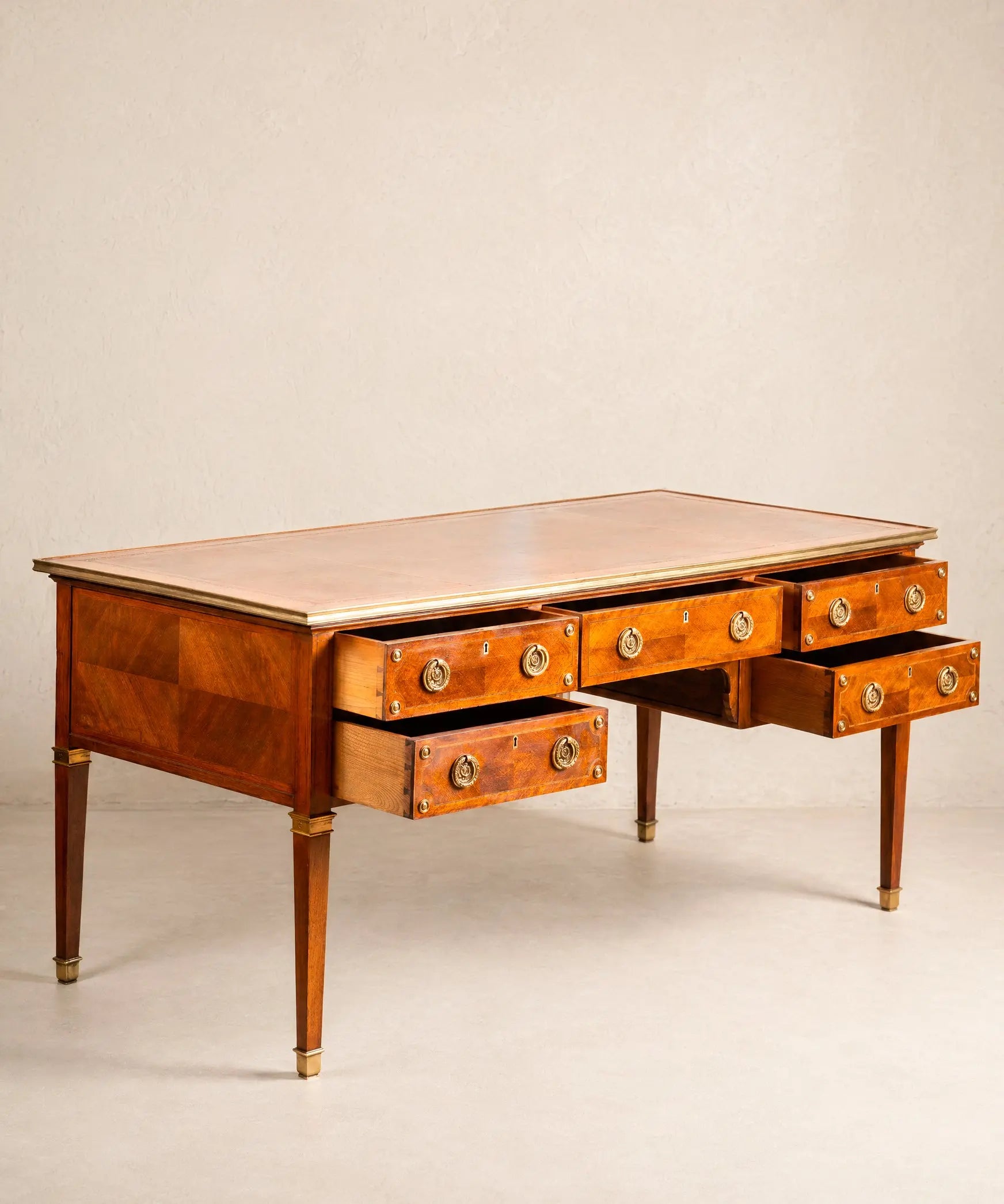 Gran escritorio de centro estilo Luis XVI de madera con cinco cajones y herrajes de bronce.