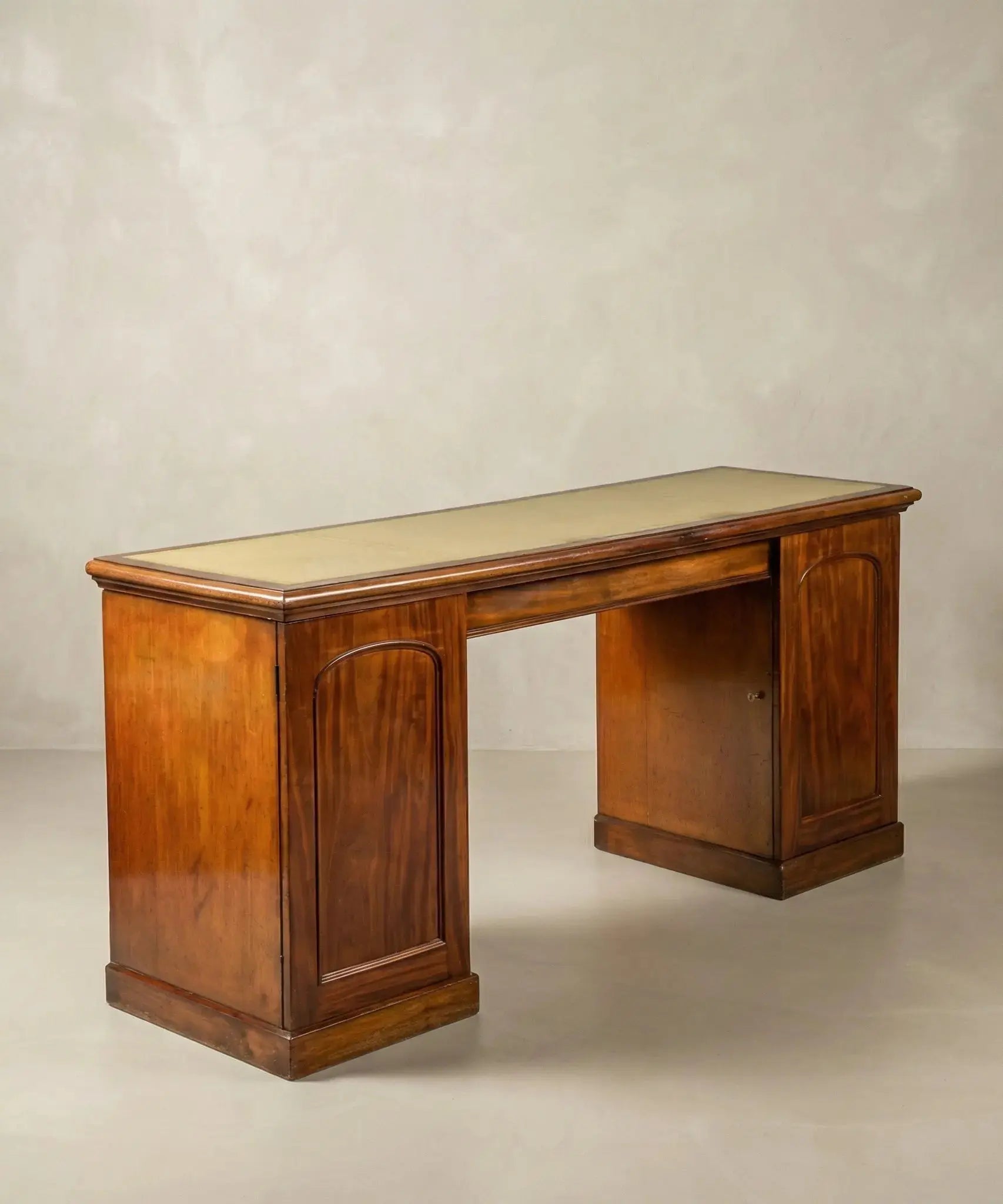 Escritorio antiguo de doble pedestal en madera de caoba con paneles tallados y diseño clásico.