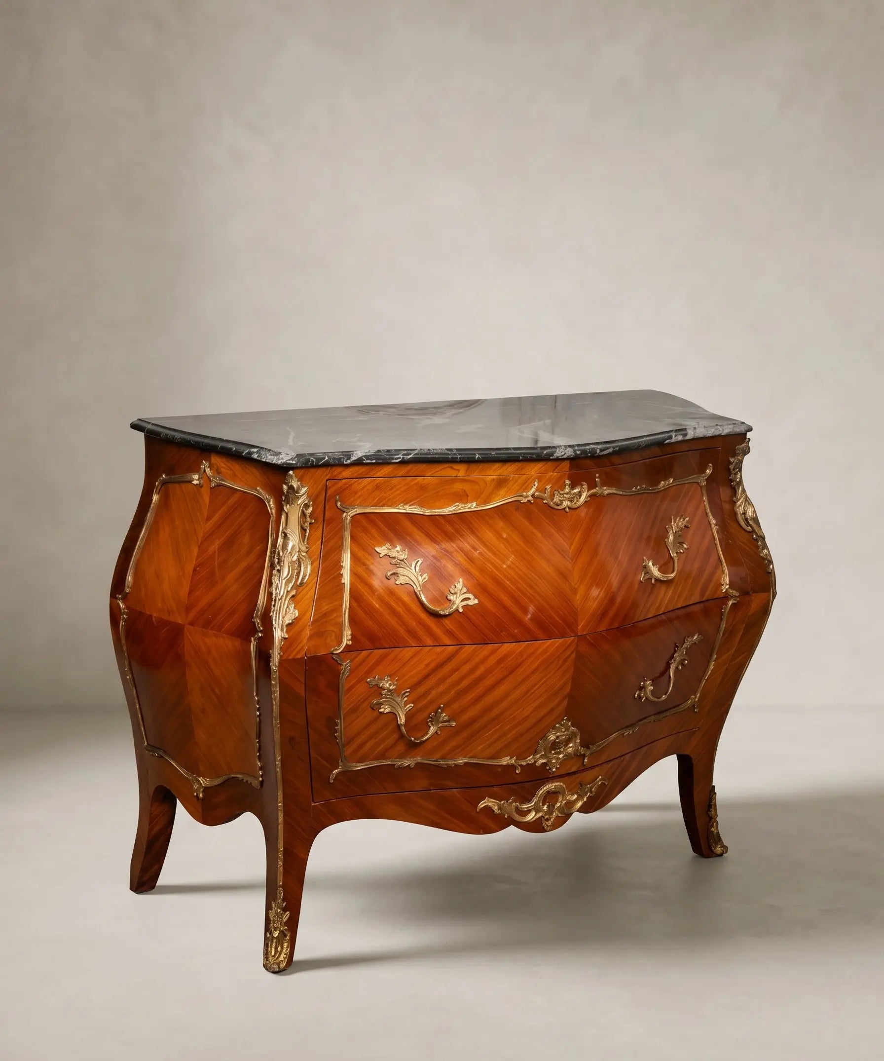 Gran cómoda bombé de estilo Luis XV en madera de palisandro con bronces dorados y tapa de mármol.