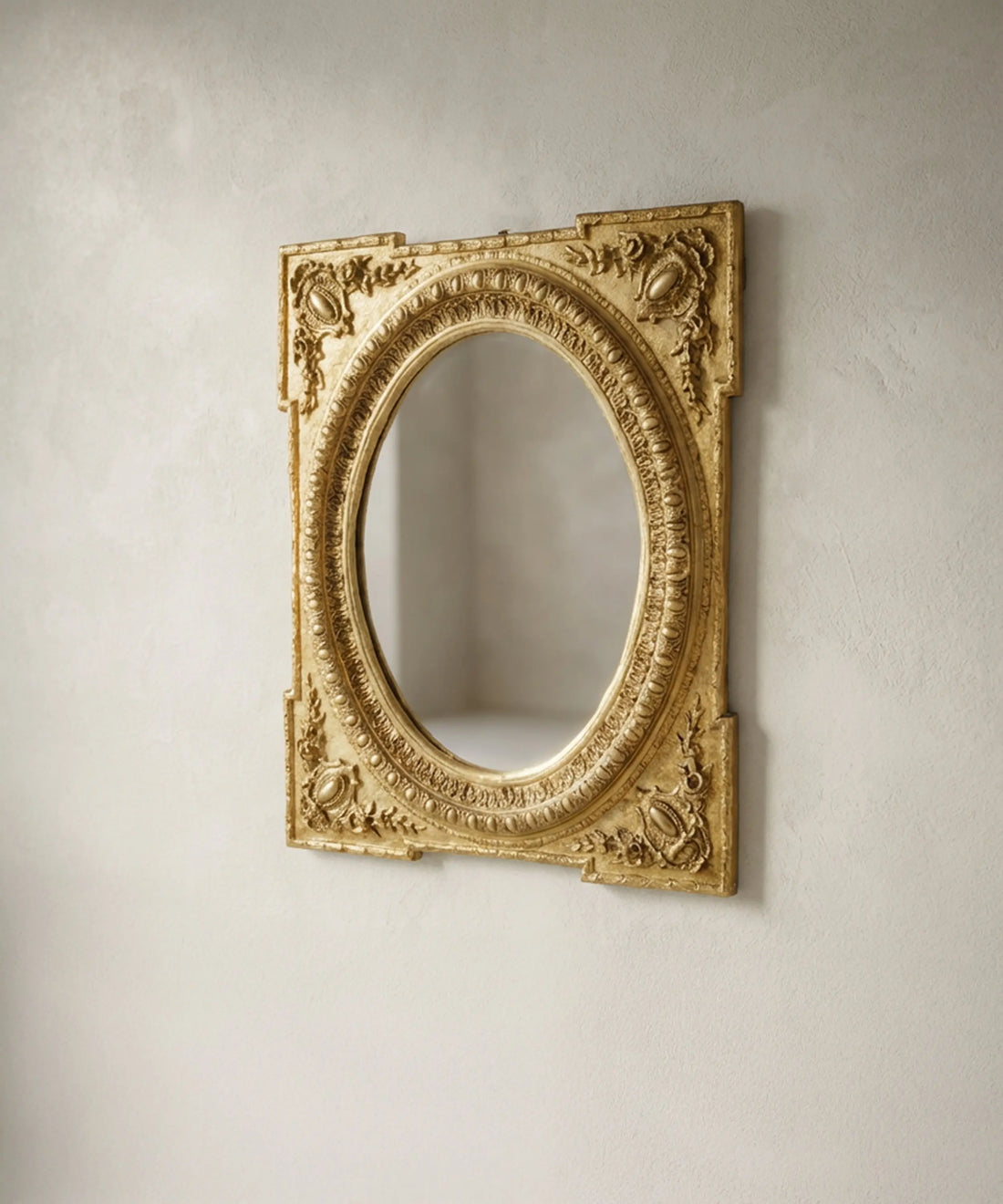 Vista en perspectiva de espejo clásico dorado mostrando los relieves florales y la moldura oval.