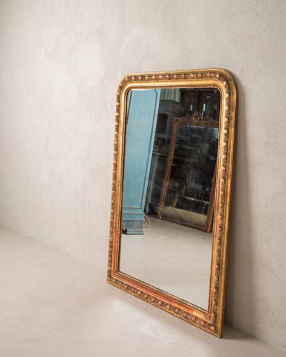 Espejo antiguo dorado vista lateral apoyado en la pared, friso de óvalos — Antique Arte y Decoración