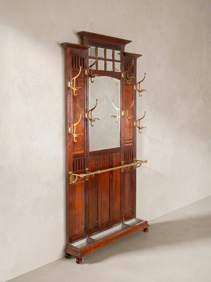 Mueble recibidor antiguo de madera de caoba con espejo central y colgadores de bronce.