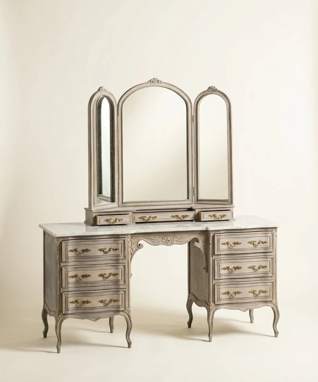 Gran tocador vintage de madera gris decapé con espejo tríptico y patas curvas estilo Luis XV.