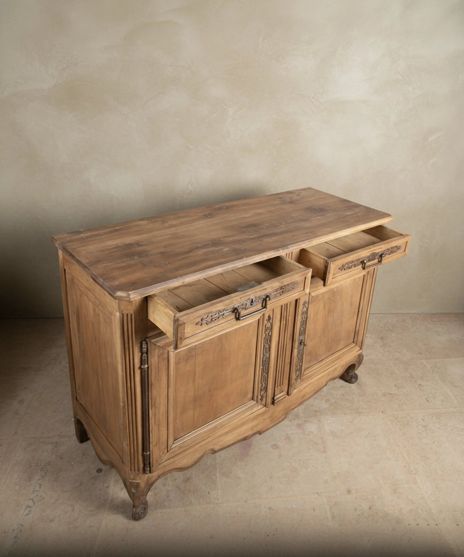 Encimera rústica de tablones de madera cruda con nudos e imperfecciones naturales en mueble antiguo.