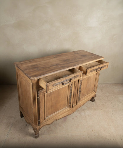 Encimera rústica de tablones de madera cruda con nudos e imperfecciones naturales en mueble antiguo.