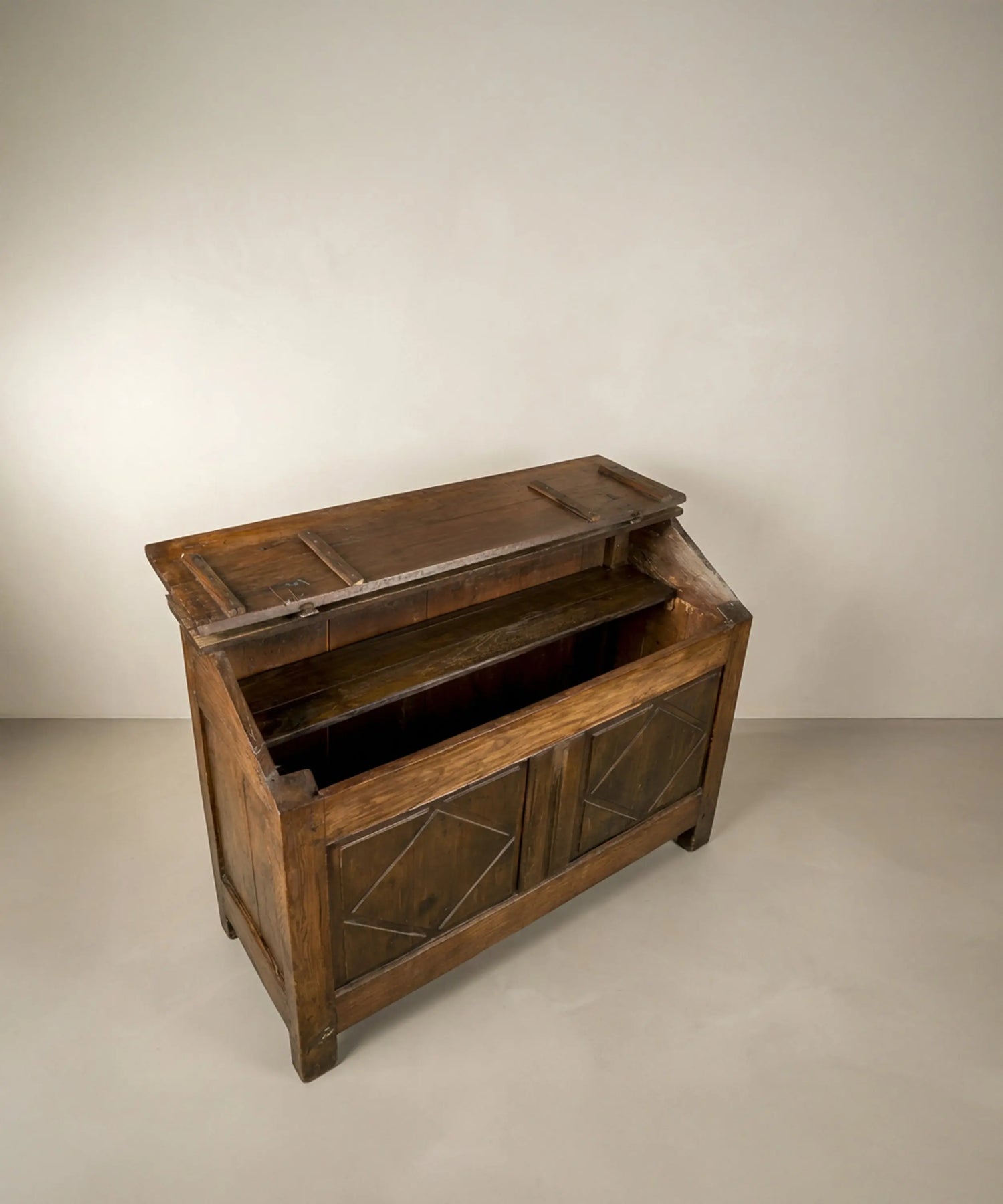 Vista superior l en ángulo de arca  antigua de madera con tapa inclinada y tallas de rombos.