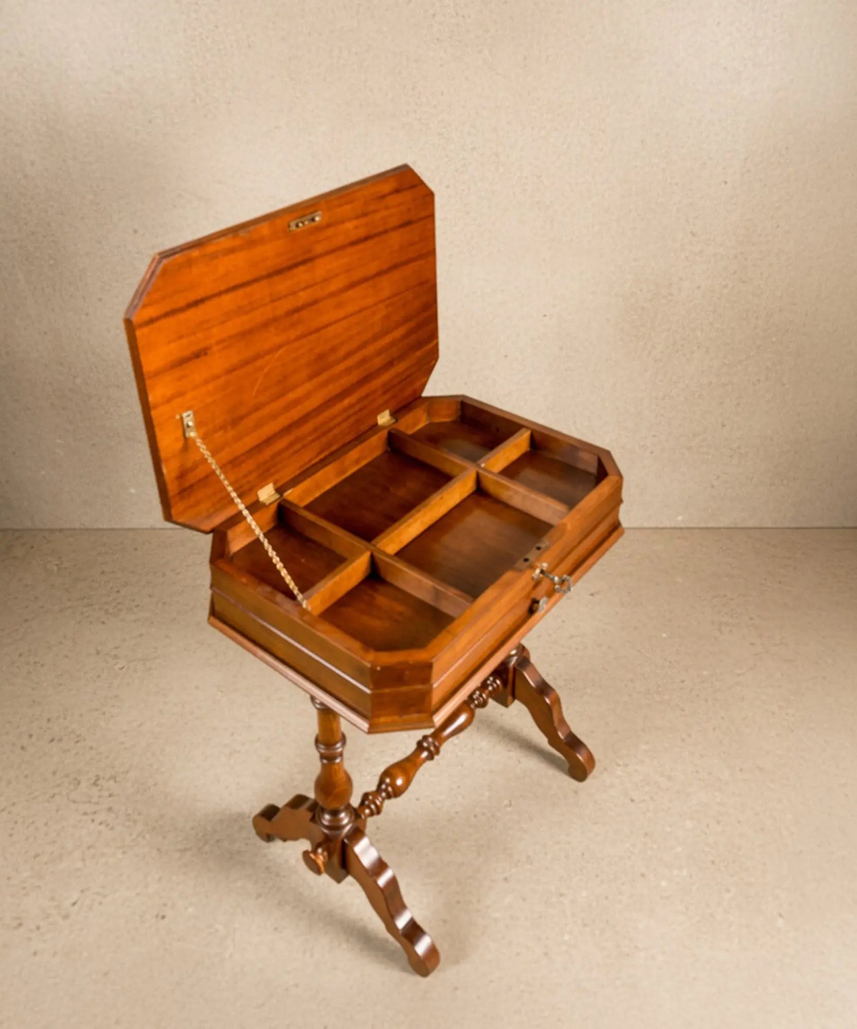 Detalle del cajón inferior de la mesa de costura con tirador de latón antiguo.