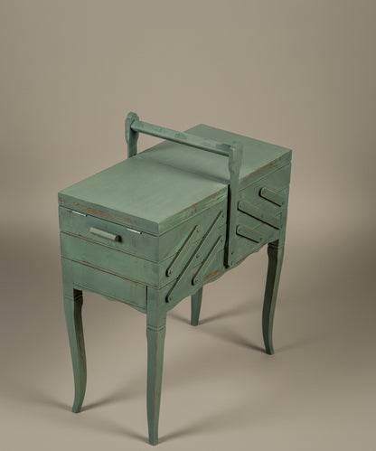 Vista aérea lateral del mueble costurero cerrado destacando la estructura de acordeón