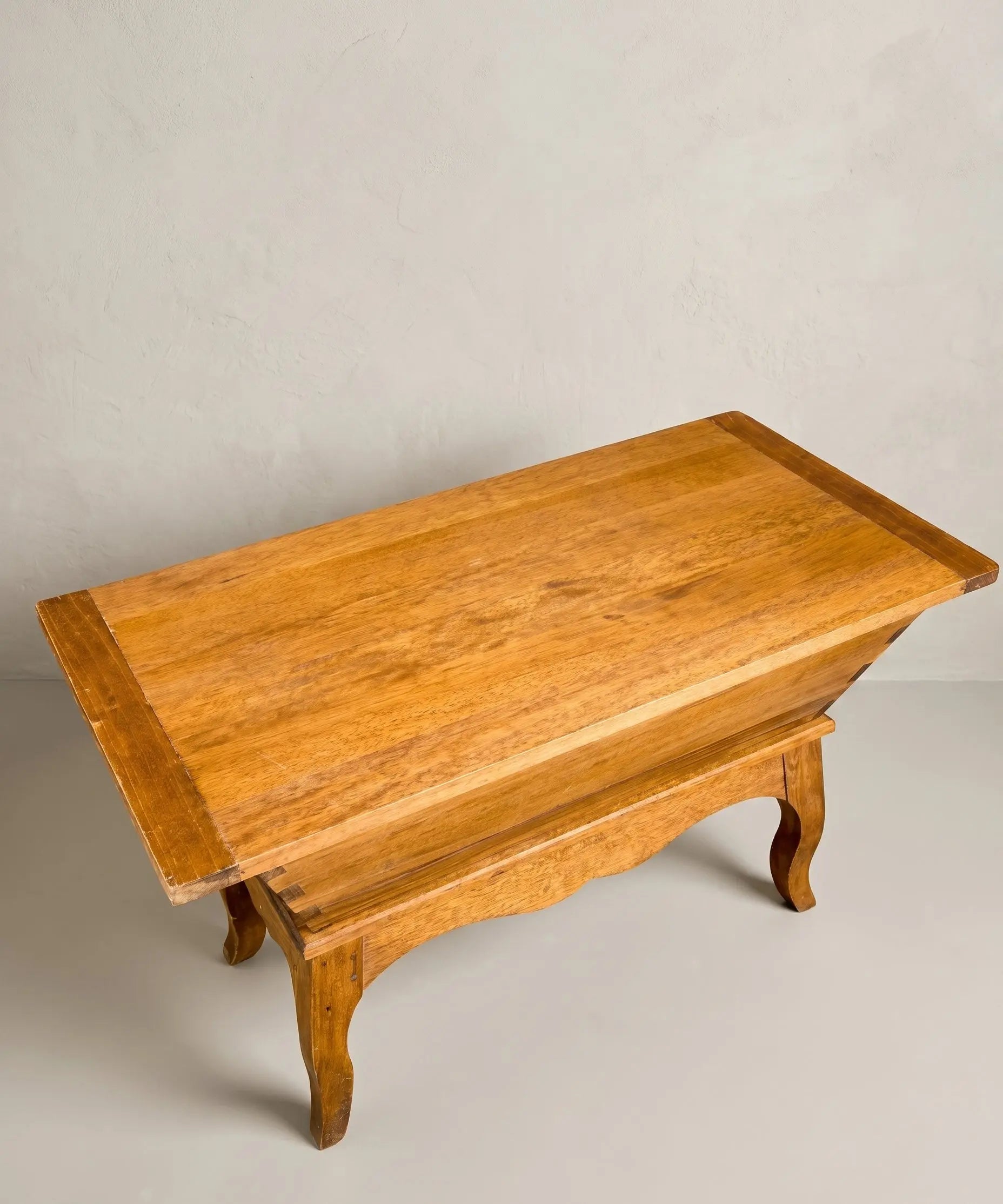 vista superior Mesa antigua tipo artesa de madera maciza con patas curvas y tapa plana estilo rústico.