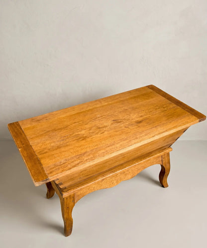 vista superior Mesa antigua tipo artesa de madera maciza con patas curvas y tapa plana estilo rústico.