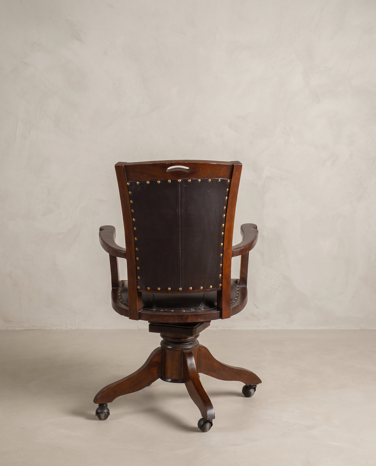 Sillón giratorio vintage vista trasera con respaldo en piel y empuñadura calada — Antique Arte y Decoración