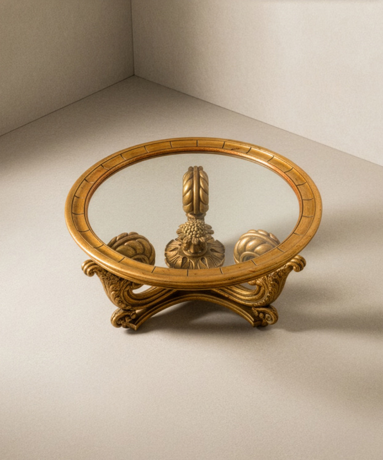 Perspectiva superior mostrando el cristal transparente y la simetría de las patas talladas en oro.