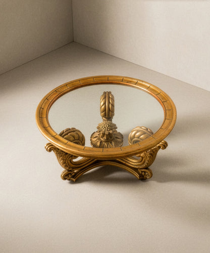 Perspectiva superior mostrando el cristal transparente y la simetría de las patas talladas en oro.