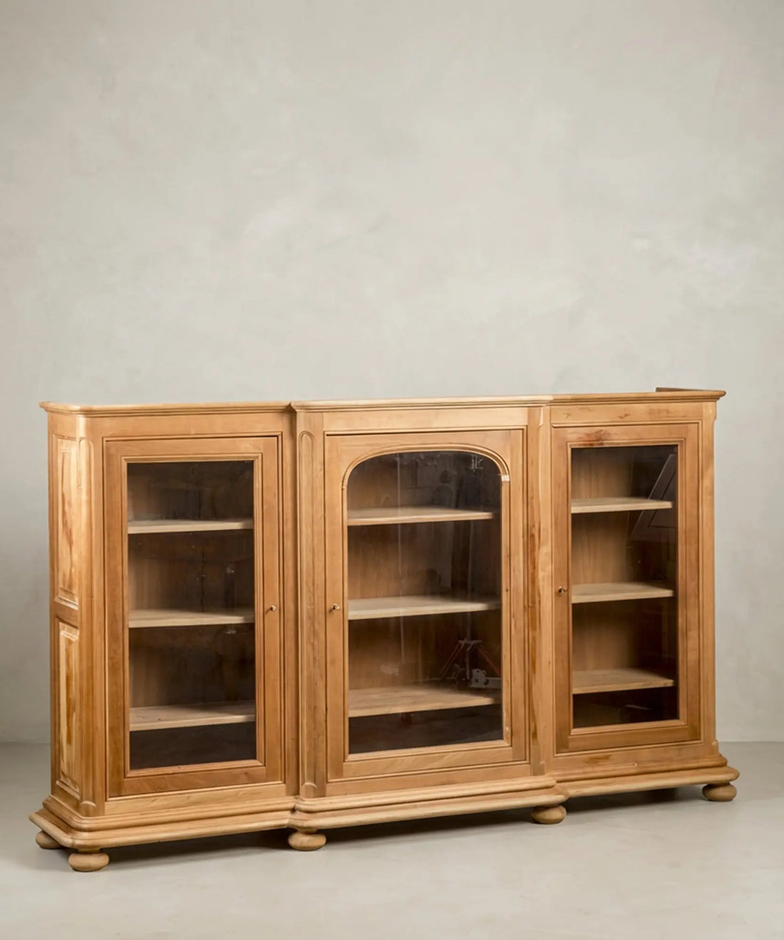 Vista lateral del aparador resaltando las molduras y las patas de bola torneadas.
