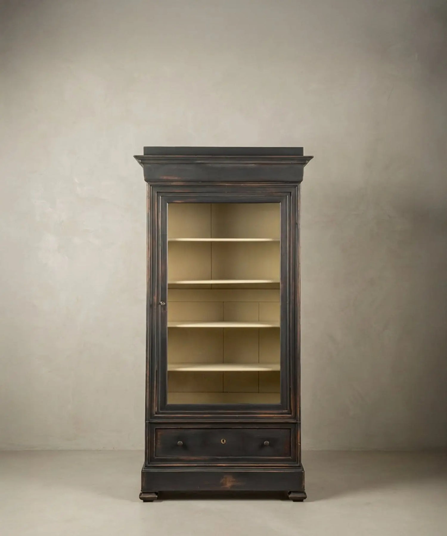 Vitrina de madera negra ebonizada de estilo francés vista de tres cuartos, mostrando molduras superiores y base sólida.